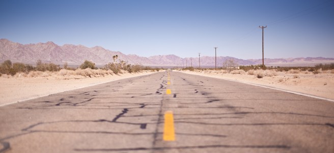 Photo of cracked asphalt across the desert.